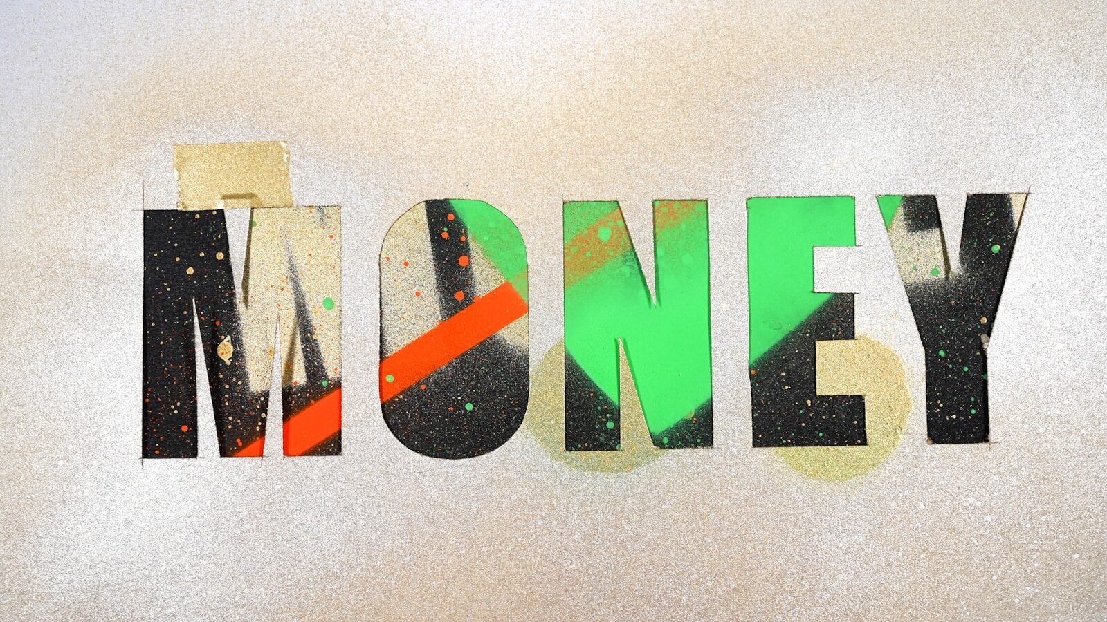 The word MONEY in stencil letters with green and orange spray paint